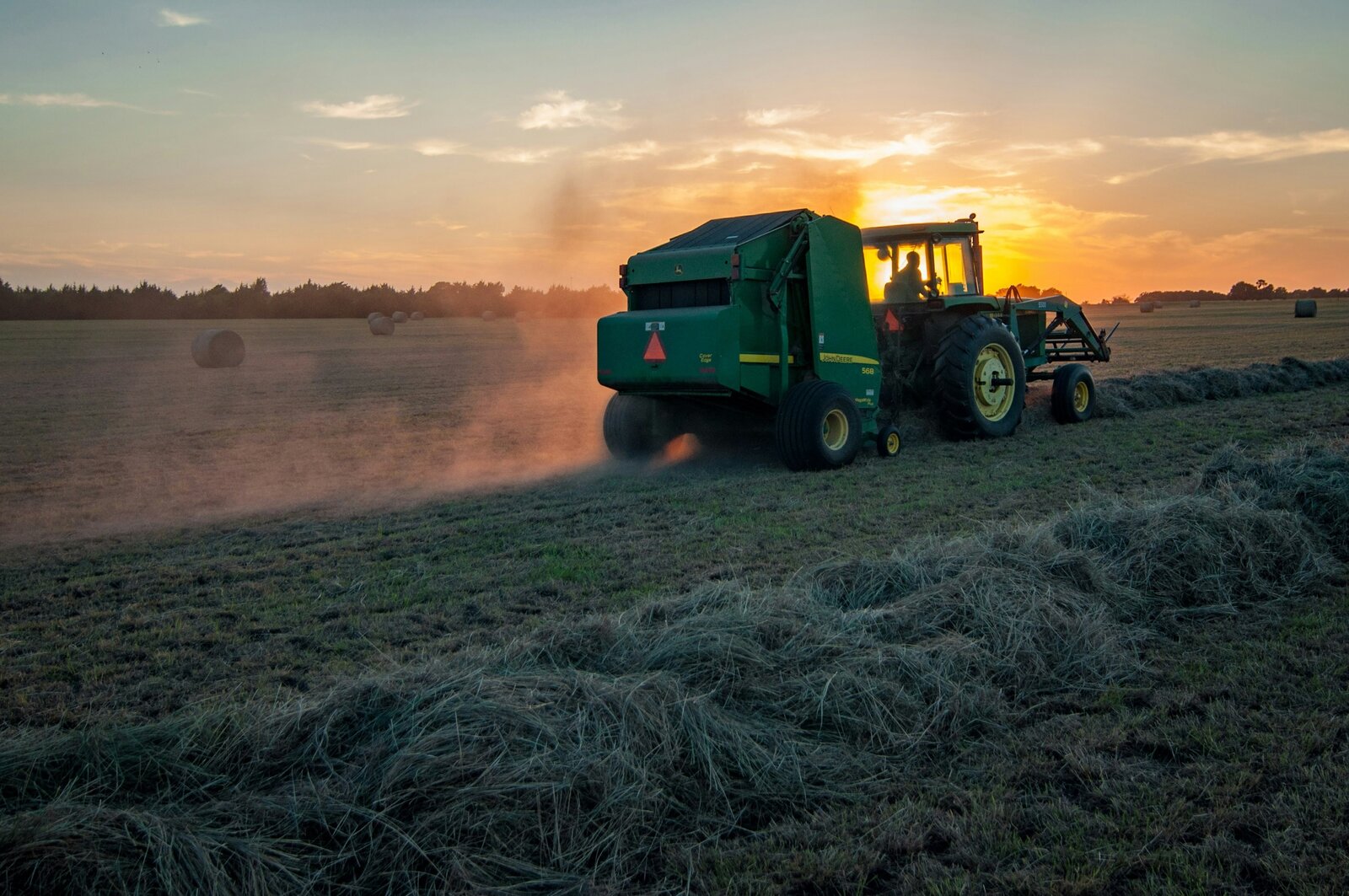 Baler working a field at sunset