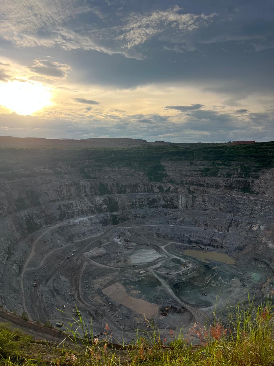 Wide view of the Catoca diamond mine open pit at sunset