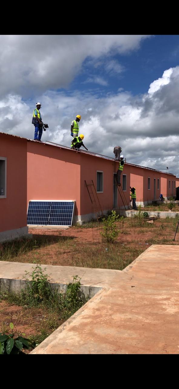 Team on the rooftop installing solar panels on a housing unit