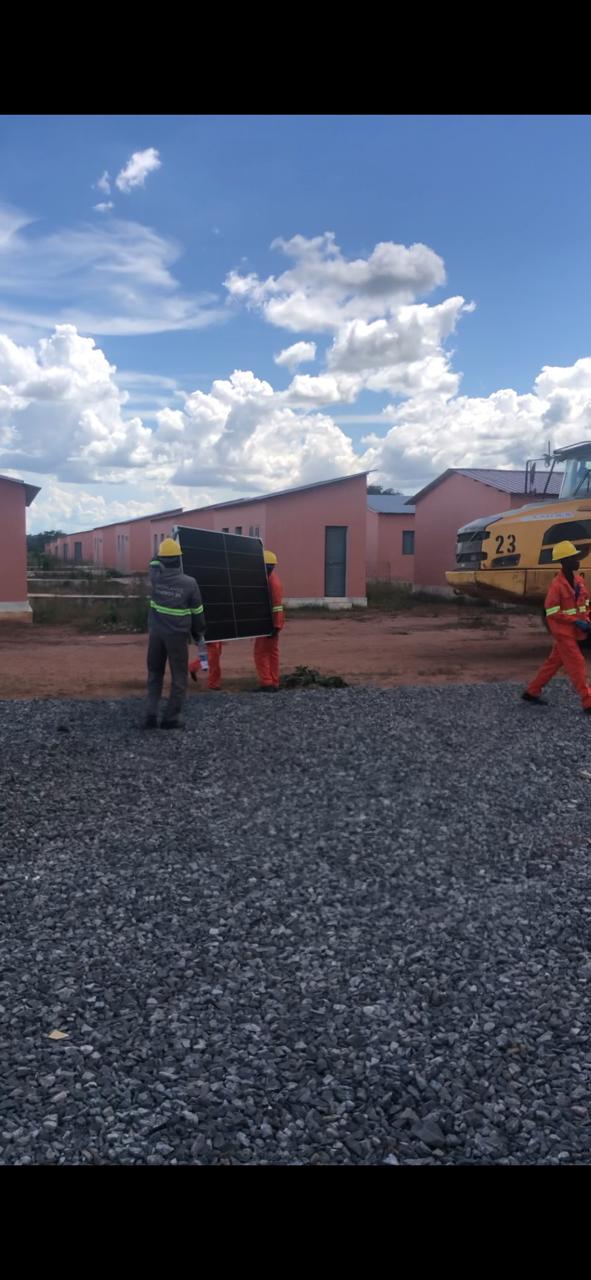 Carrying a solar panel across the housing site